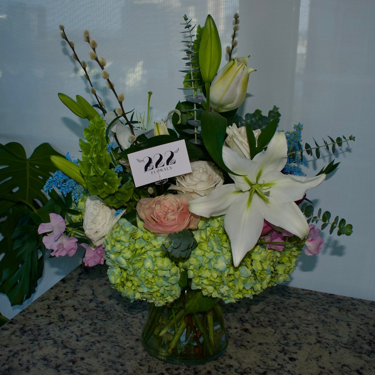 Lily and hydrangea arrangement with 222 Florals card