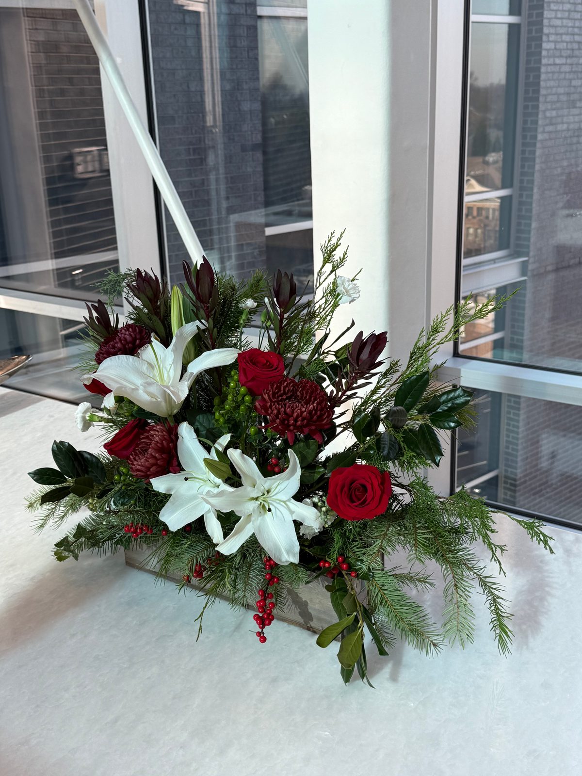 Holiday arrangement with red roses and white lilies